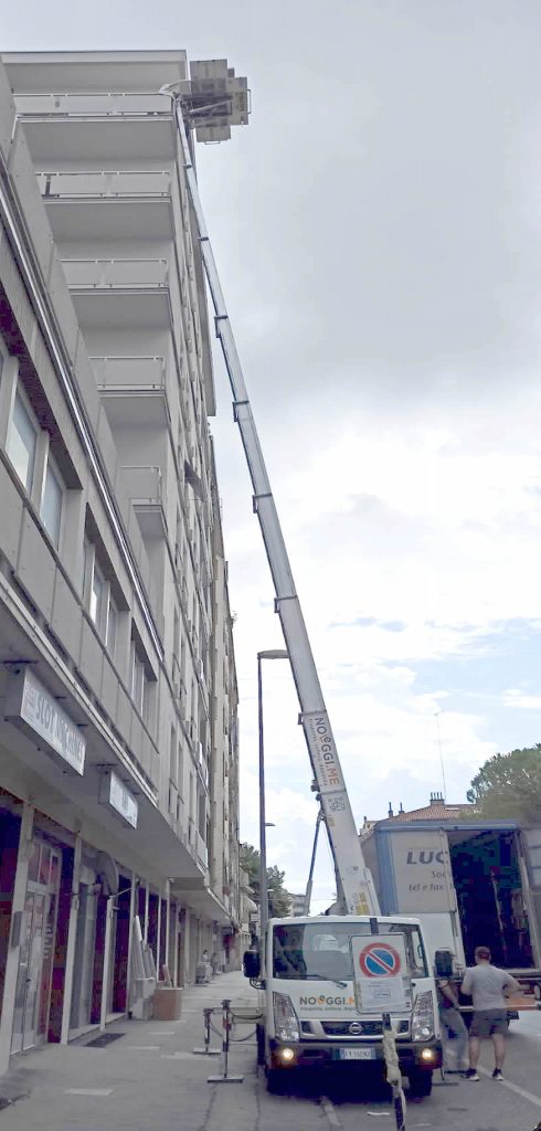 Foto di un'autoscala al lavoro. Noleggio scala per arredamenti contract in condominio - Noleggi.me